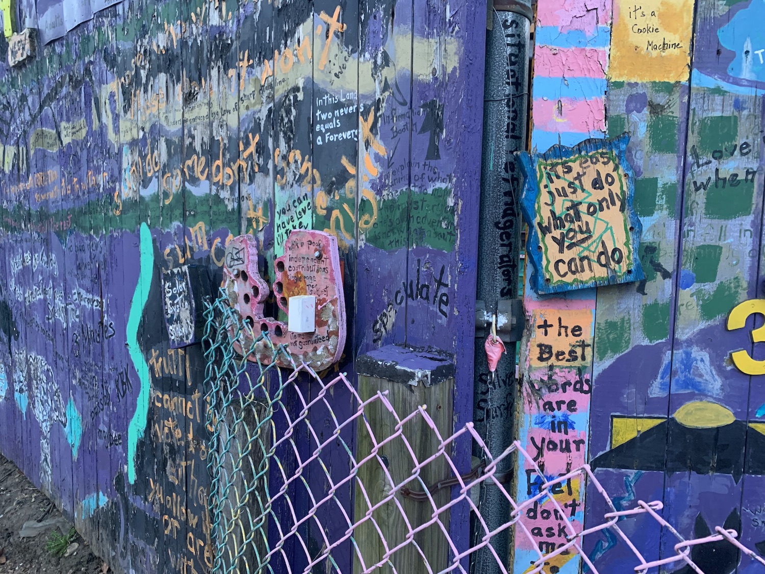 A large purple fence with whimsical sayings. I lived across this house for two separate years.