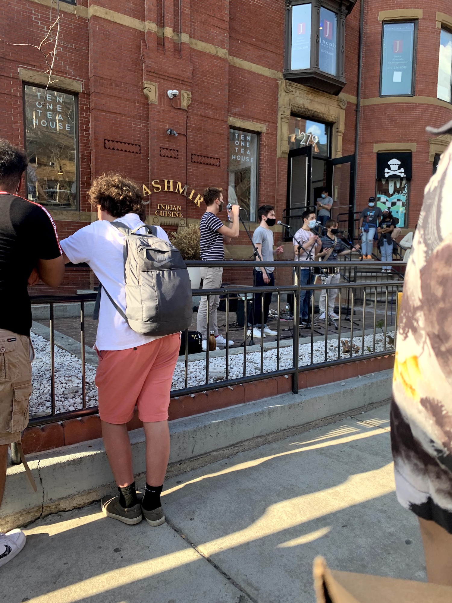 In the hub of Newbury Street, four men sing sweet tunes to a crowd of onlookers.