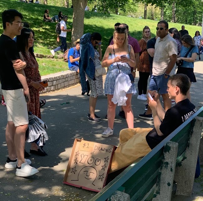 A man offers $1 dollar drawings to a crowd in the park.