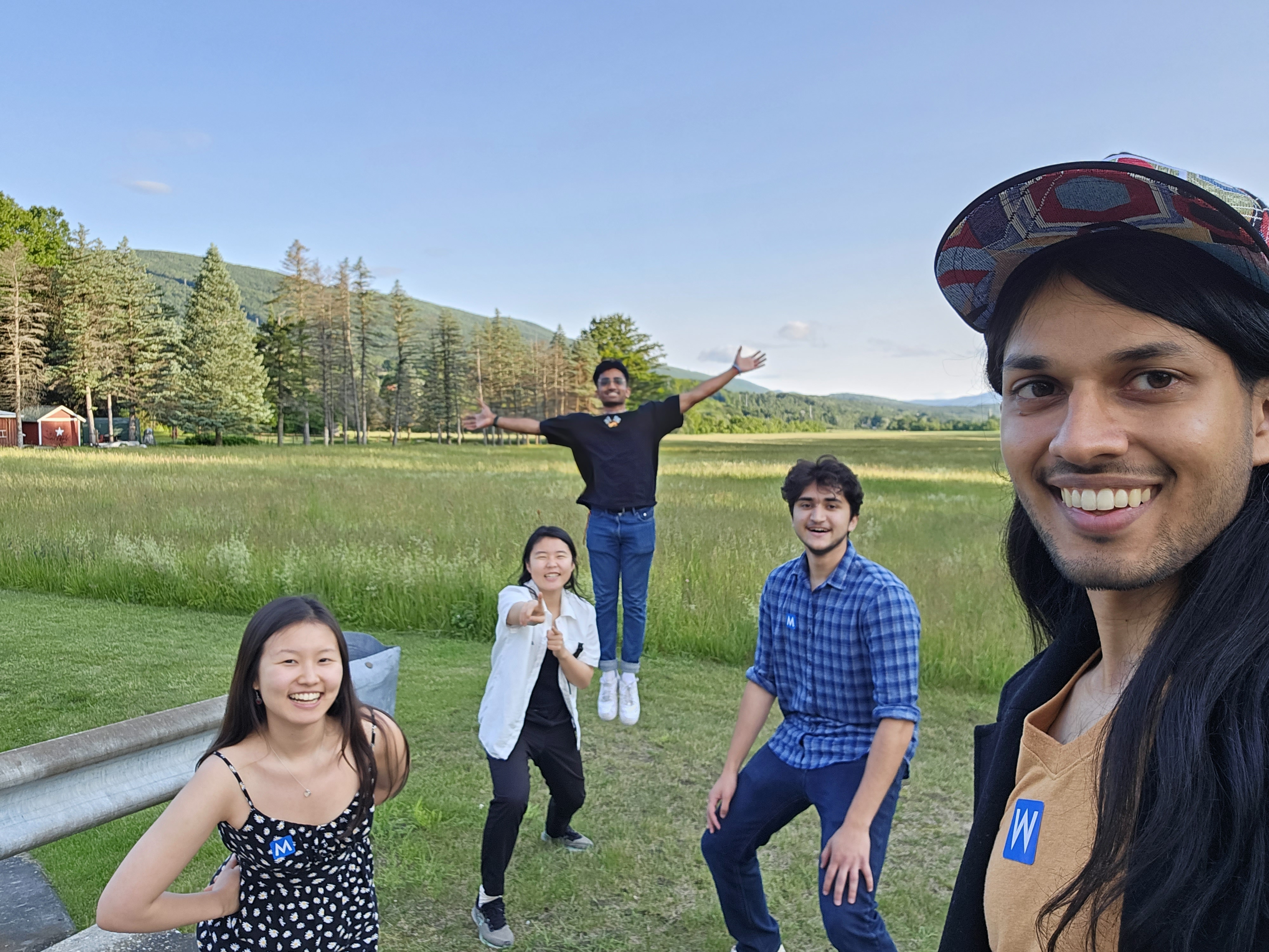 5 friends smiling in a grassy field