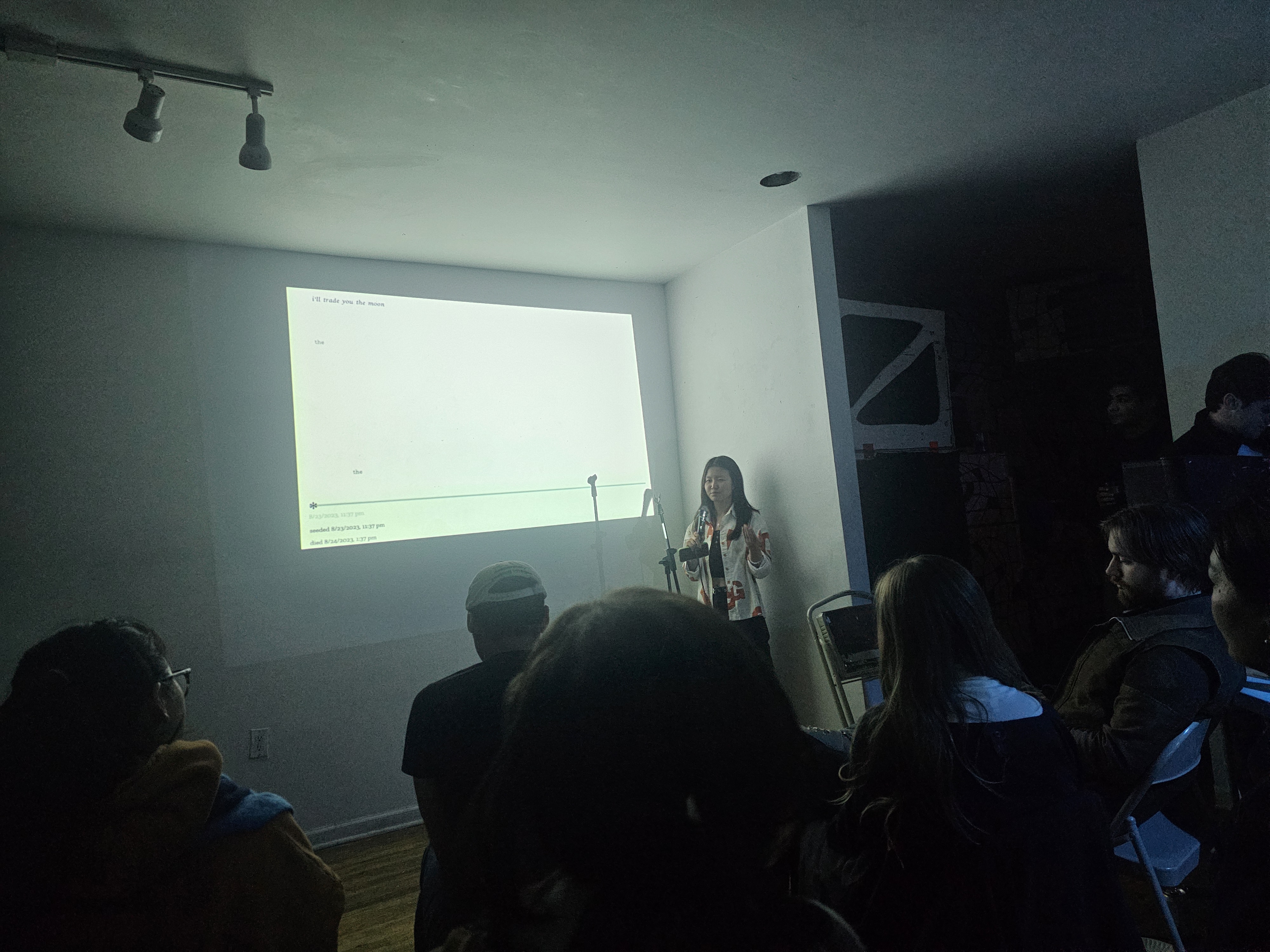 me standing in front of a projection doing a reading of my poem
